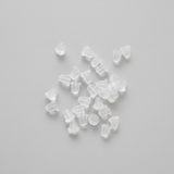 Clear plastic beads scattered on a textured fabric surface